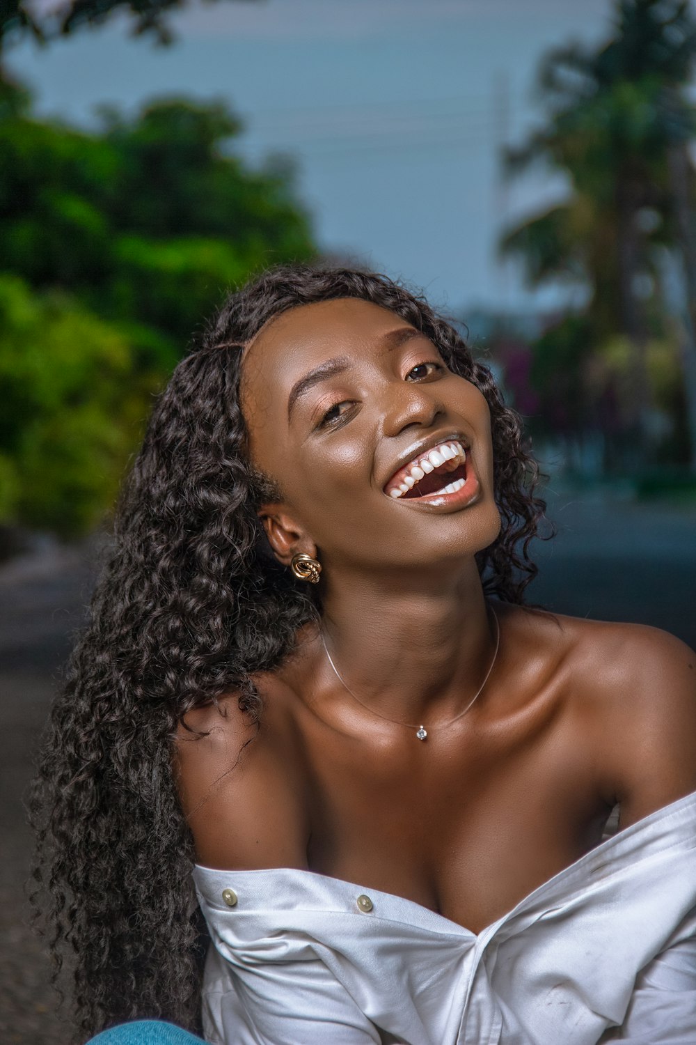 smiling woman in white off shoulder shirt