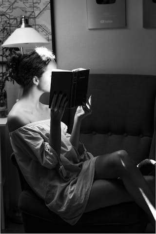 Portrait of a person reading a book in a cozy, well-lit room
