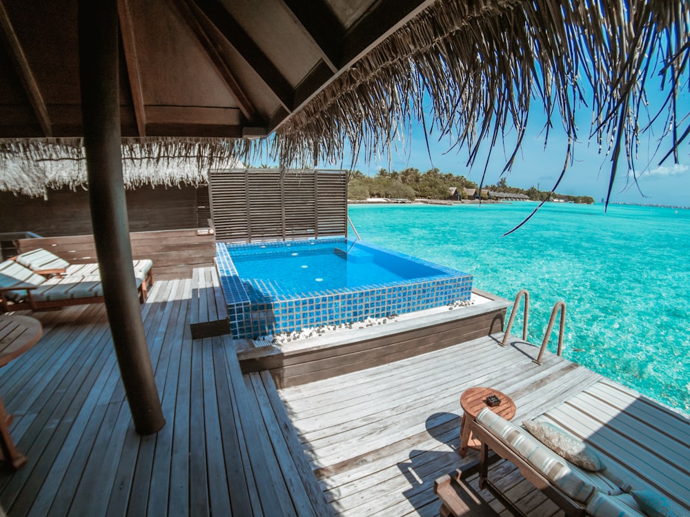 brown wooden lounge chairs beside swimming pool during daytime