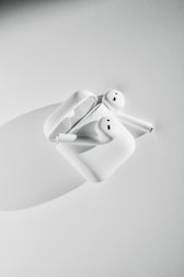 A pair of wireless earbuds displayed on a clean white surface with charging case open.