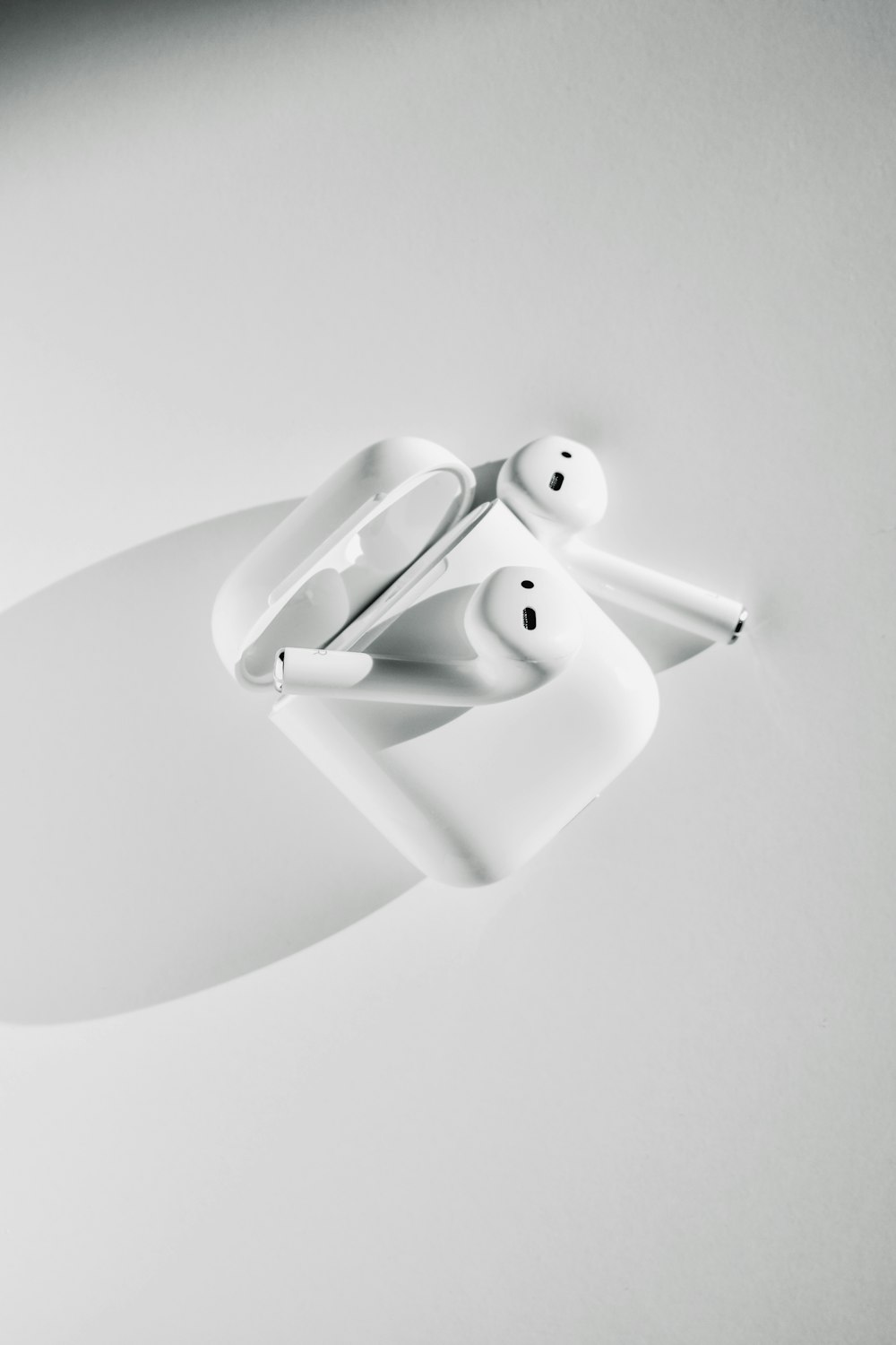 white apple earpods on white surface