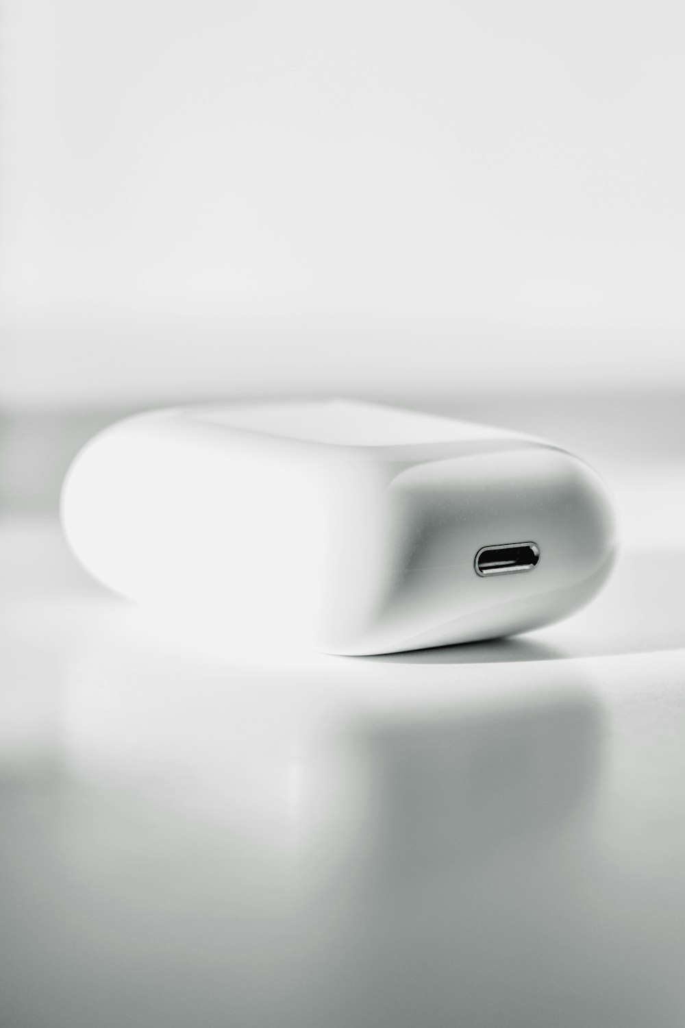 white apple charging case on white textile