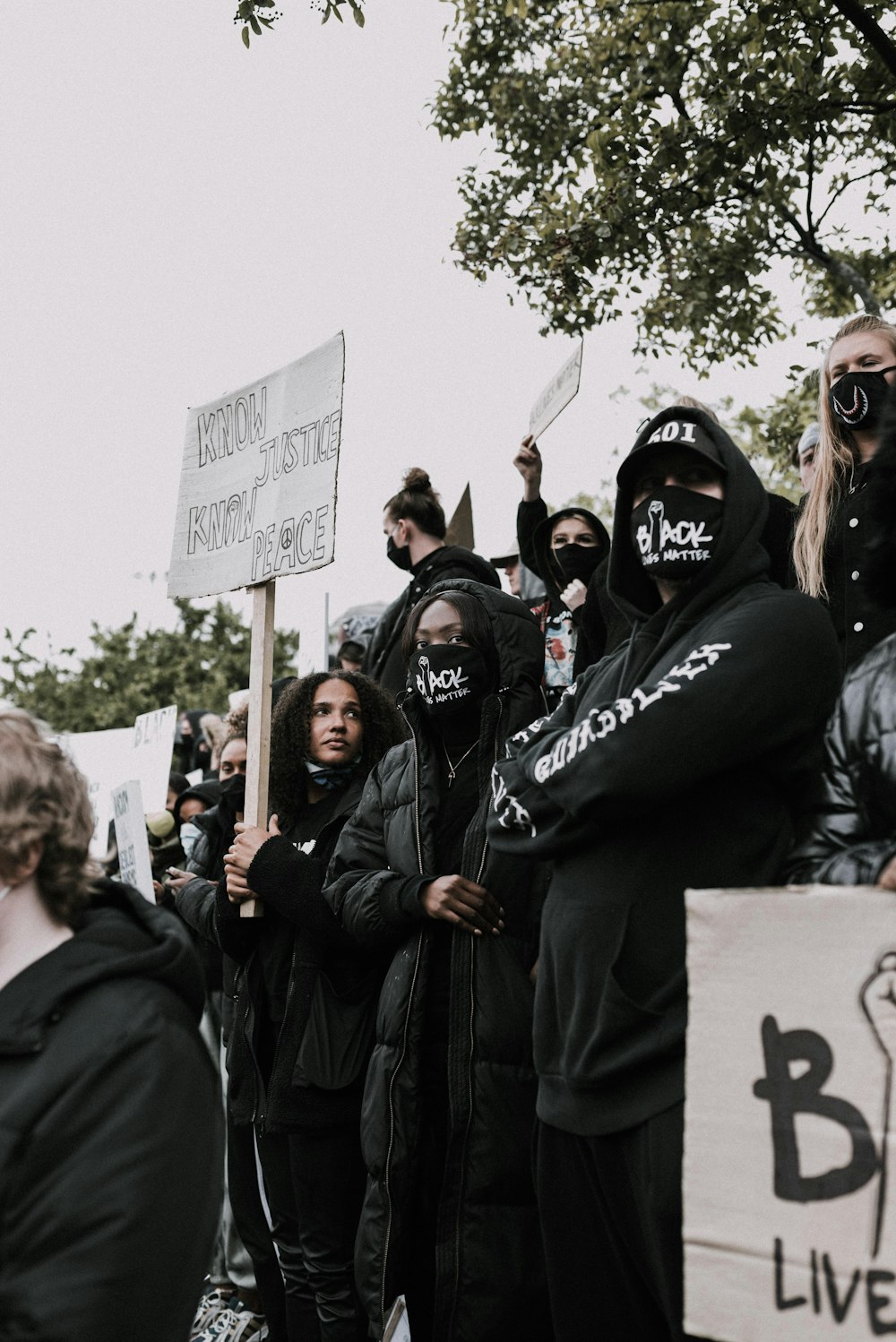 group of people wearing black jacket holding white board