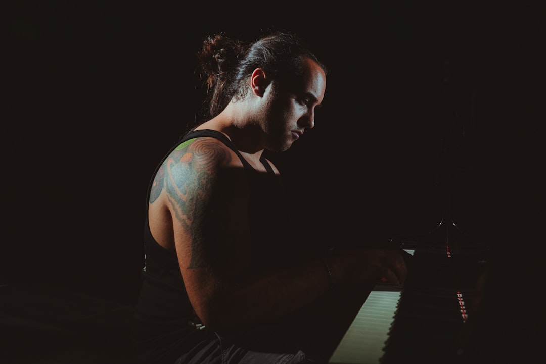 woman in black tank top playing piano