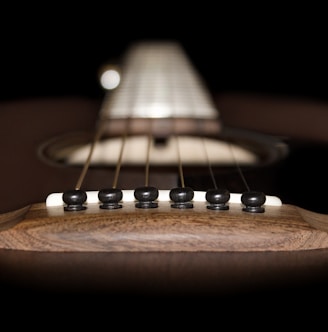 brown acoustic guitar in close up photography