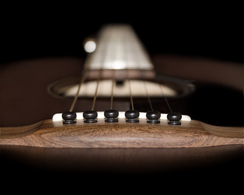 brown acoustic guitar in close up photography