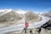 2 person walking on snow covered field near snow covered mountain during daytime
