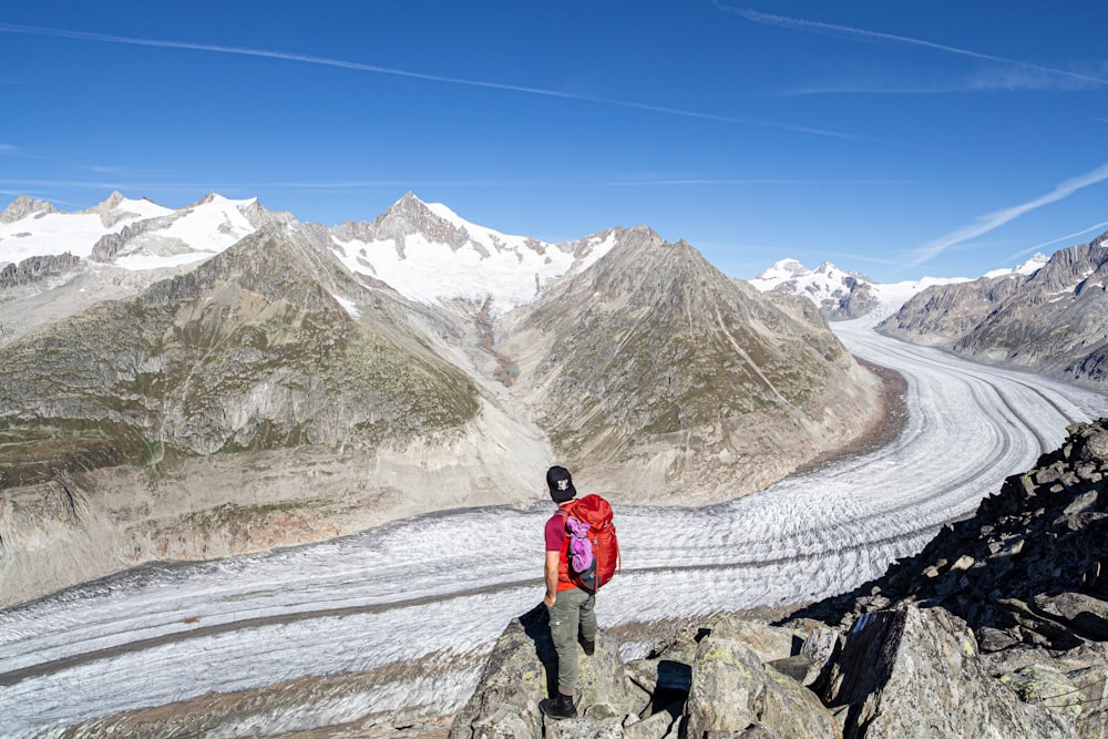 2 person walking on snow covered field near snow covered mountain during daytime