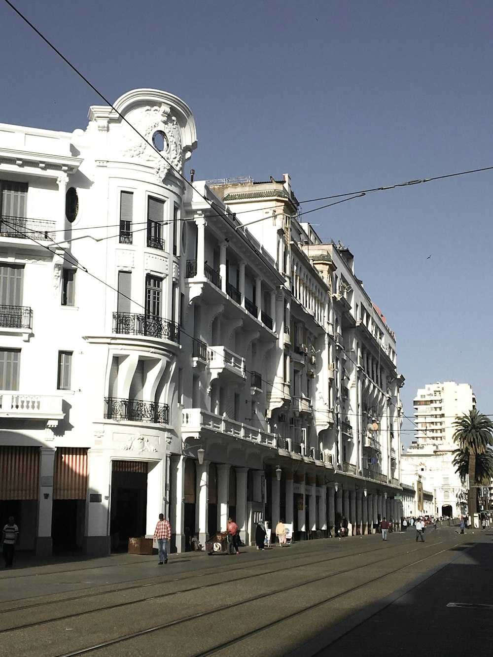 people walking on street near white concrete building during daytime