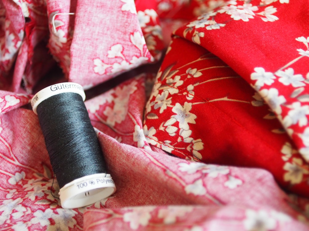 black thread on red and white floral textile