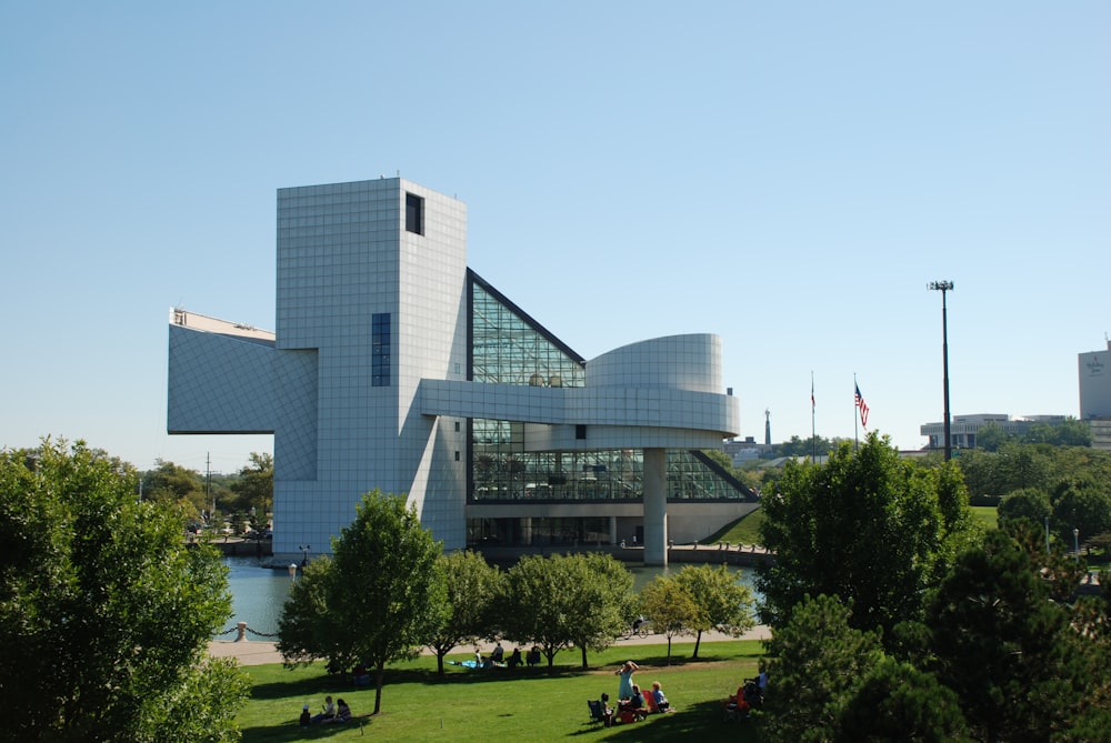 people sitting on green grass field near white concrete building during daytime