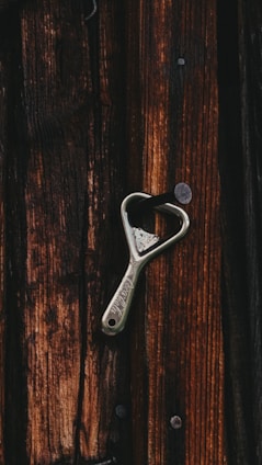 silver steel bottle opener on brown wooden table