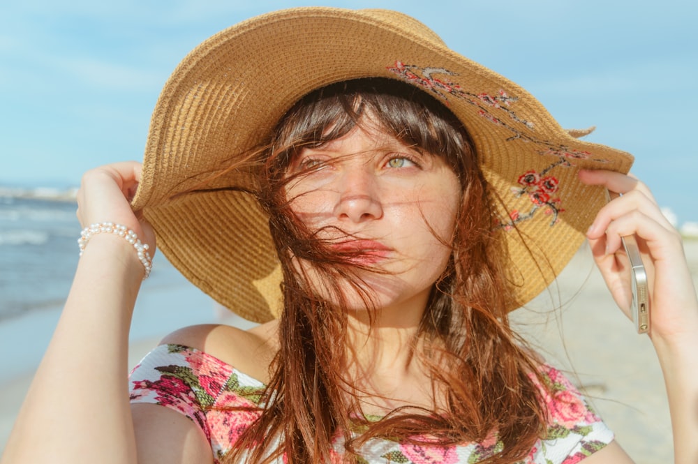 woman in brown sun hat and floral top