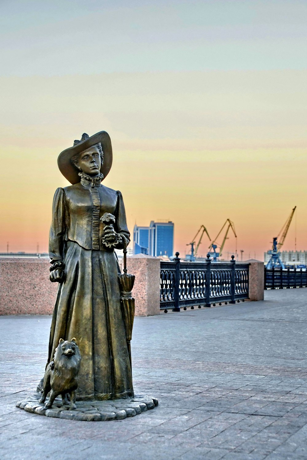 woman statue near body of water during daytime