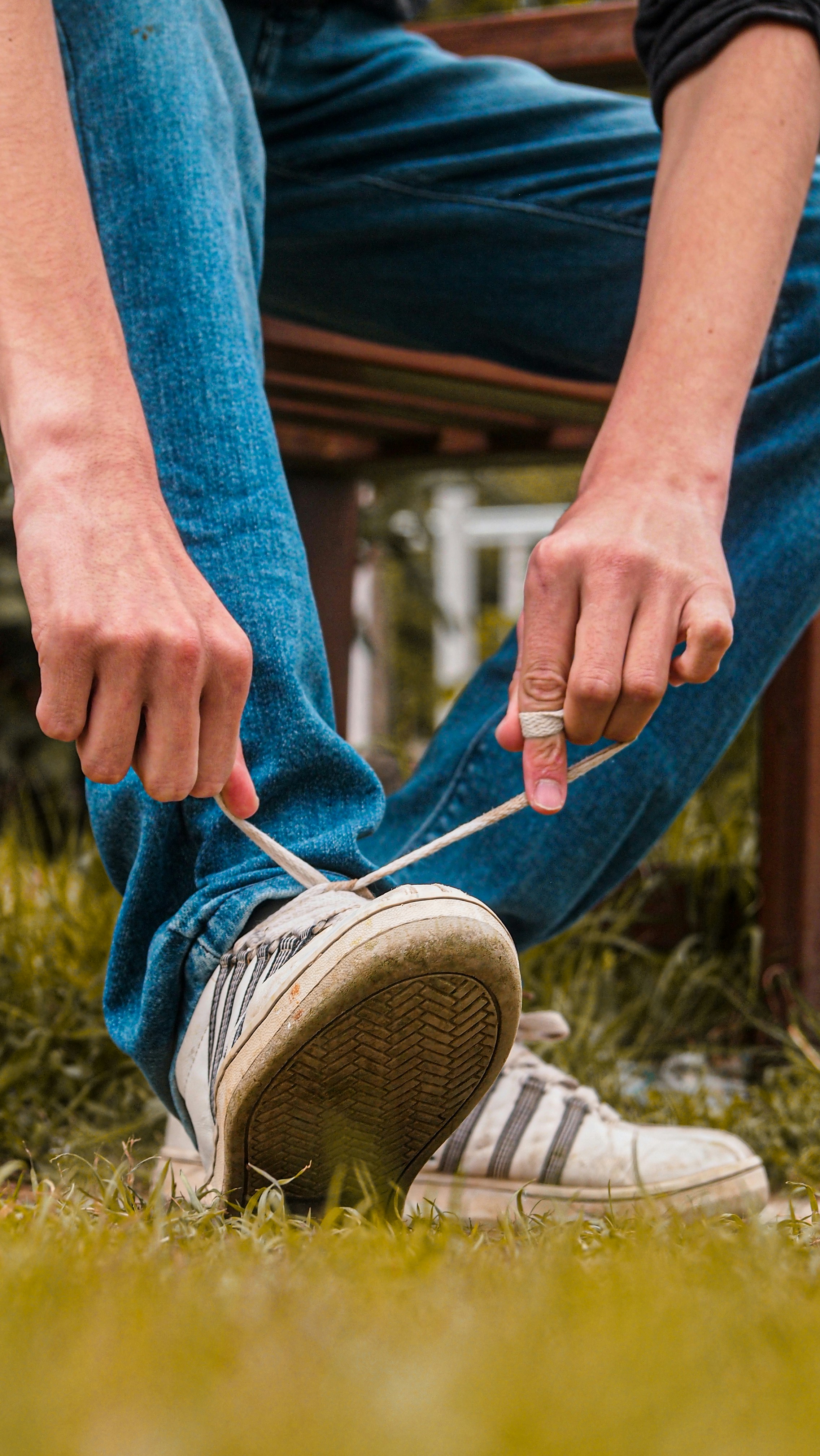 Personne en jean bleu et baskets blanches tenant un bâton photo Photo