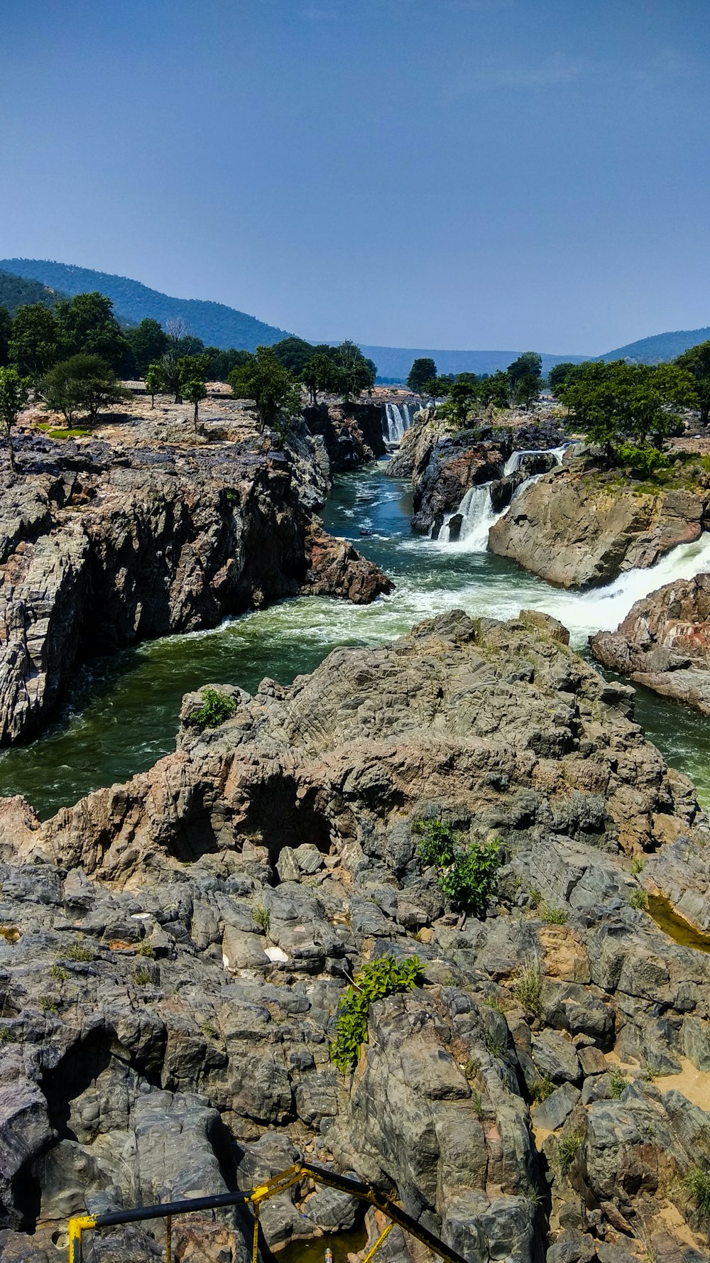 El agua cae entre las montañas rocosas marrones durante el día