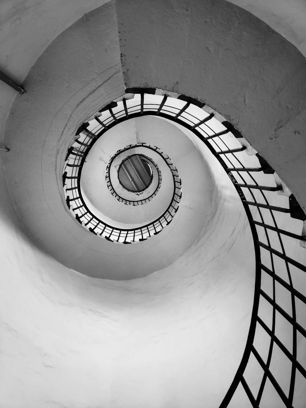 weiße Wendeltreppe mit schwarzen Metallgeländern