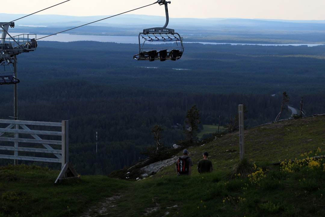 white and black cable car over green grass field during daytime