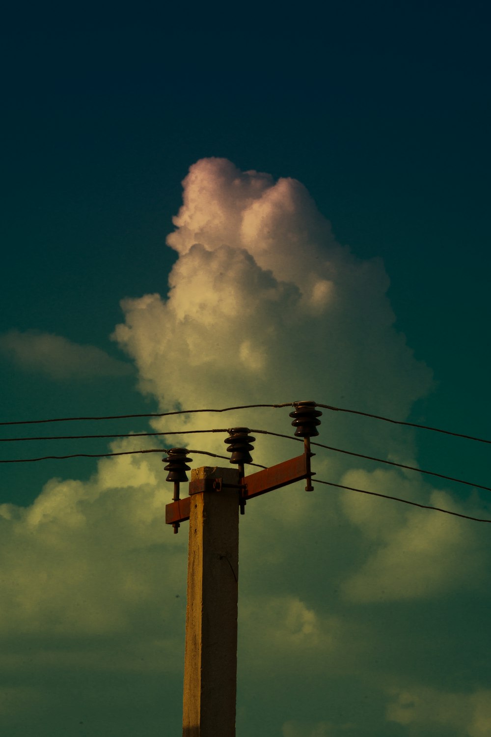 white clouds on brown electric post