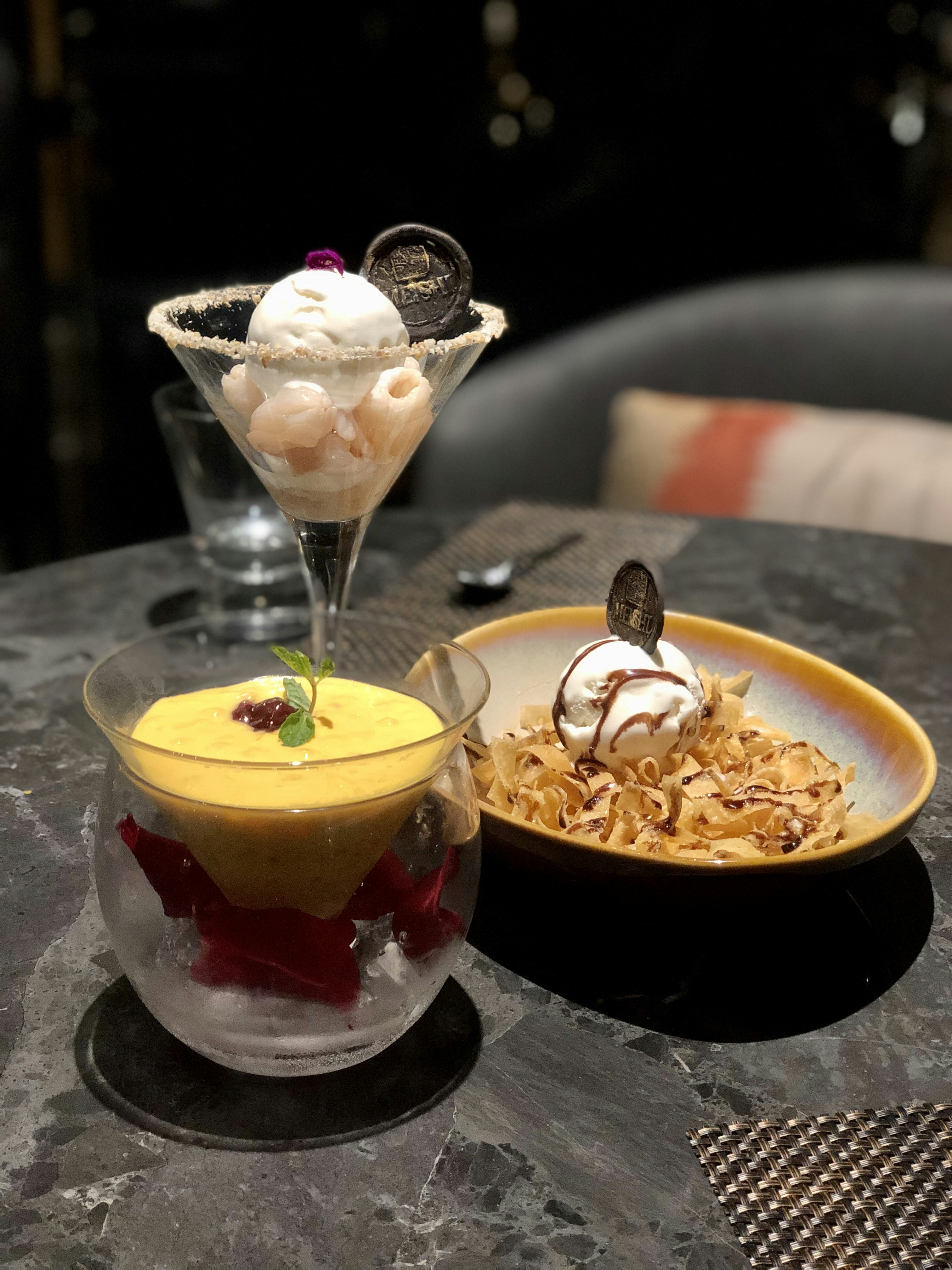 Colorful ice cream dessert with fresh fruit toppings on white plate