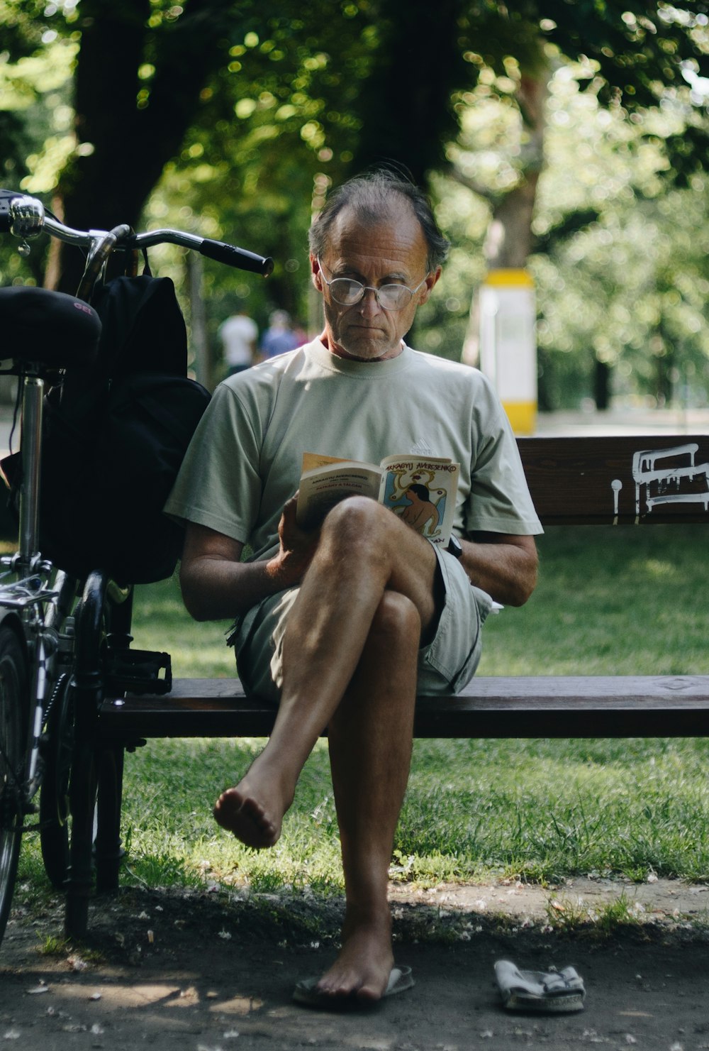 man in brown crew neck t-shirt sitting on black wooden bench during daytime