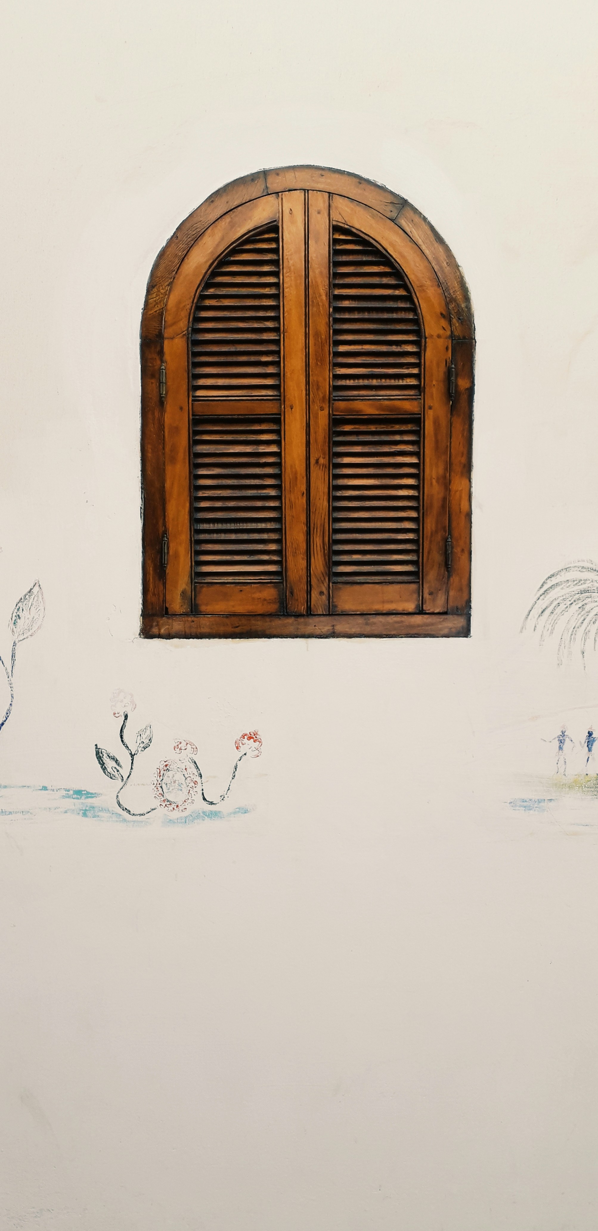ventana de madera marrón sobre pared blanca