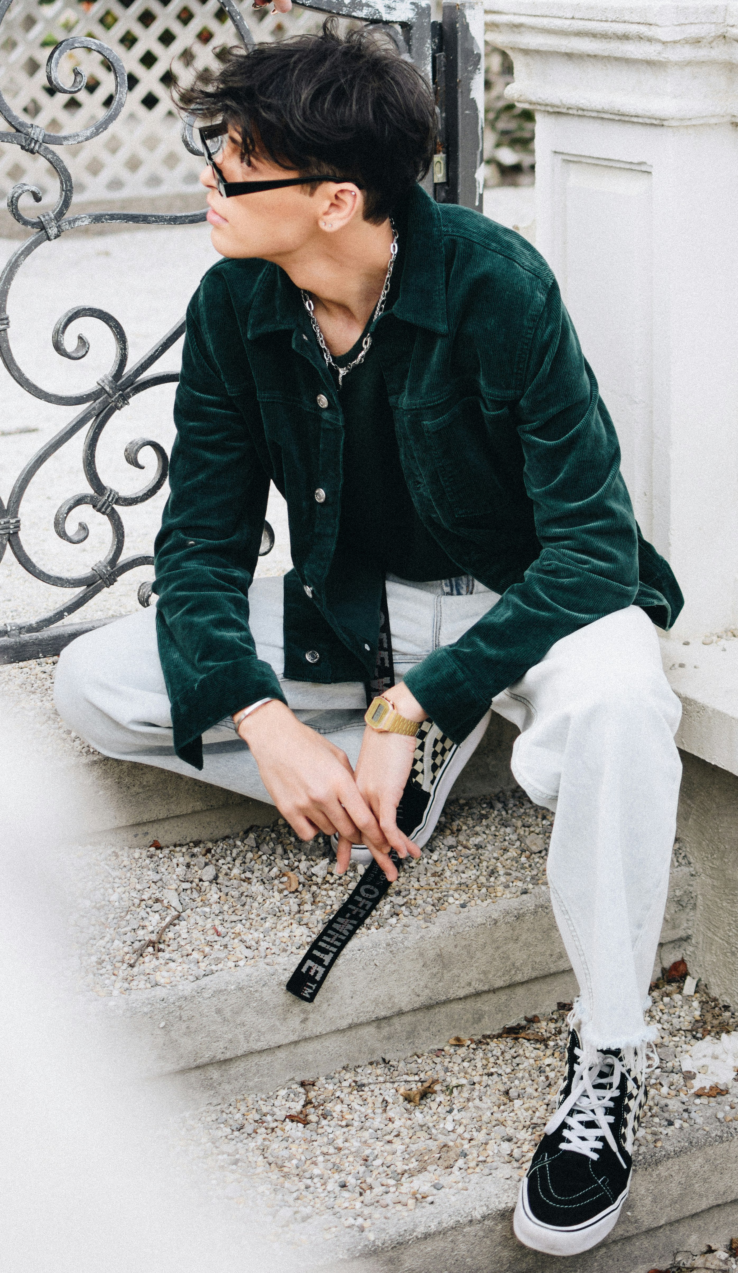 woman in green zip up jacket and white pants sitting on white and black round chair