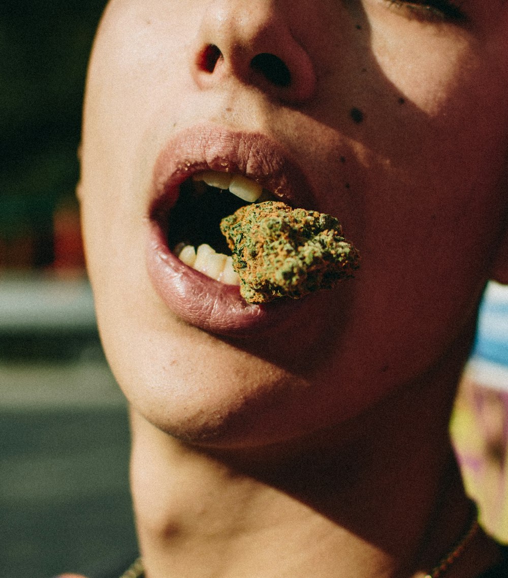 person with green kush on mouth