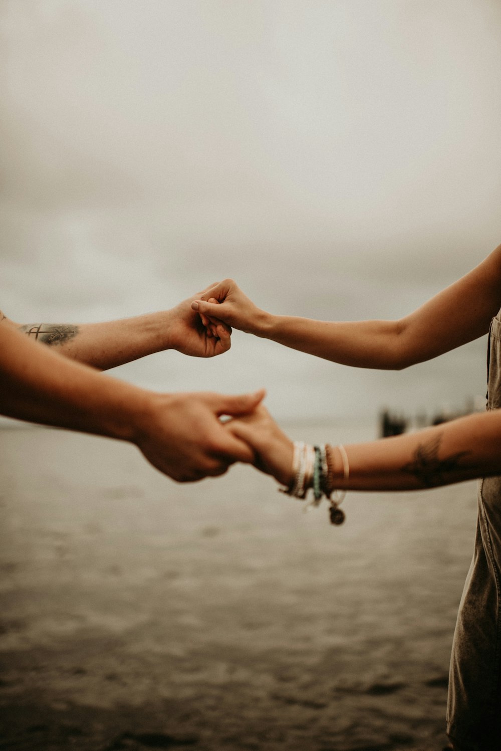 2 person holding hands on water