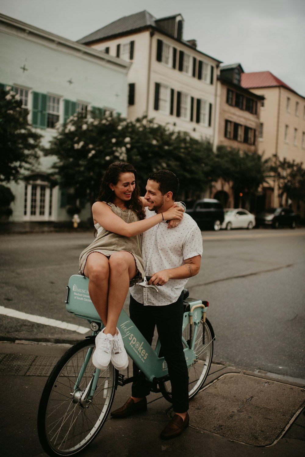 man and woman riding on bicycle on road during daytime