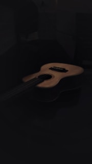 brown acoustic guitar on black background