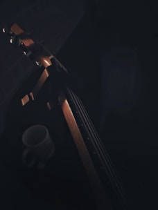 A cozy scene featuring a coffee mug with the Jesus Rocks logo beside a guitar and sheet music.