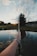 person holding silver and black stick near lake during daytime