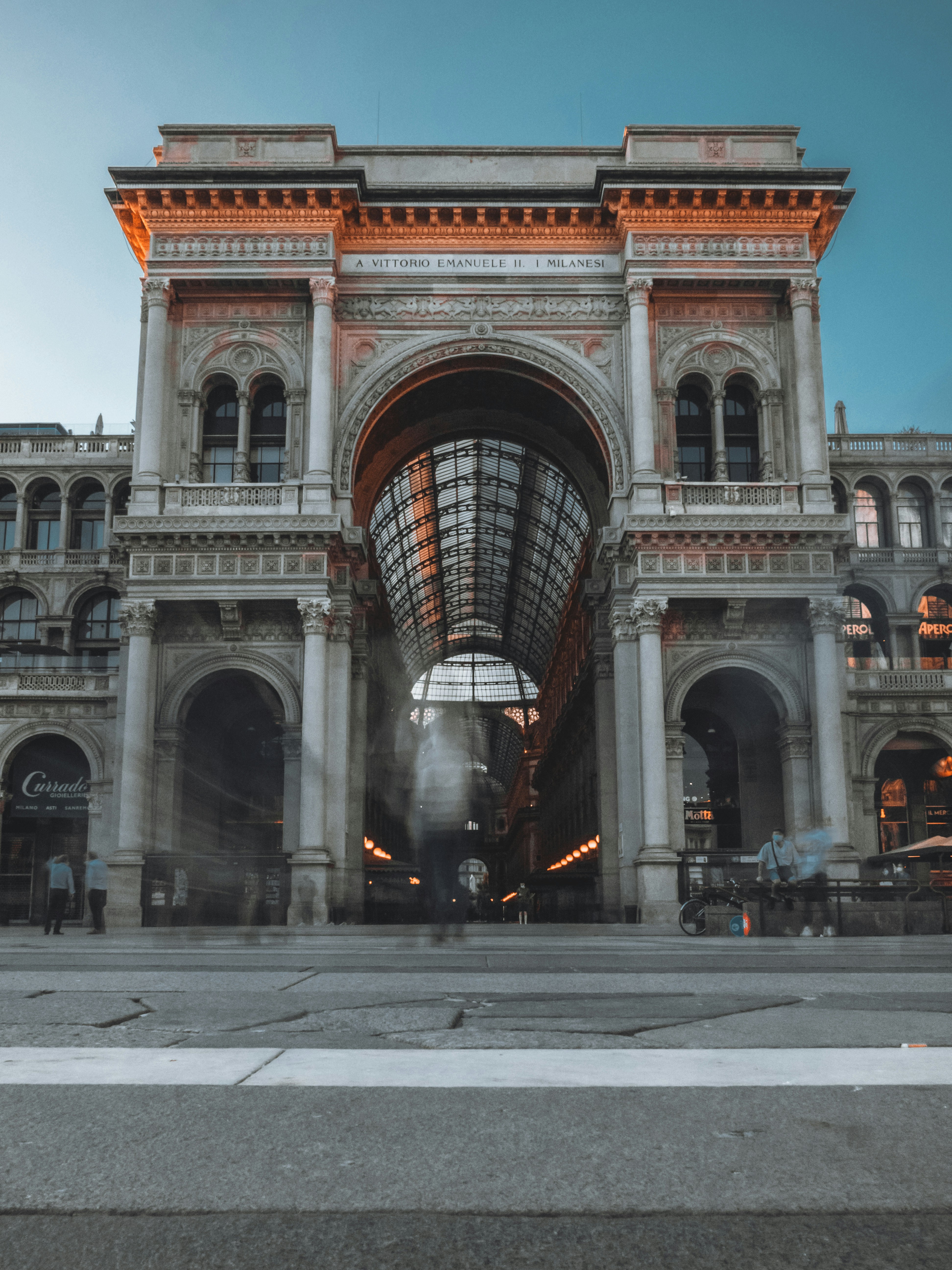 people walking on gray concrete road near brown concrete building during daytime