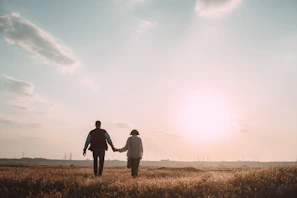 A candid shot of a couple holding hands, bathed in soft sunset glow.