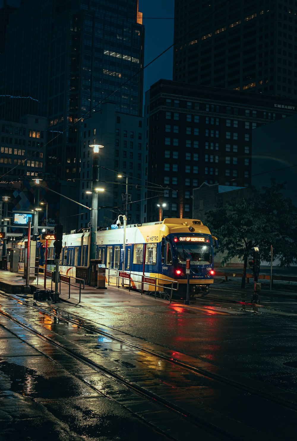 yellow and white train on city street during night time