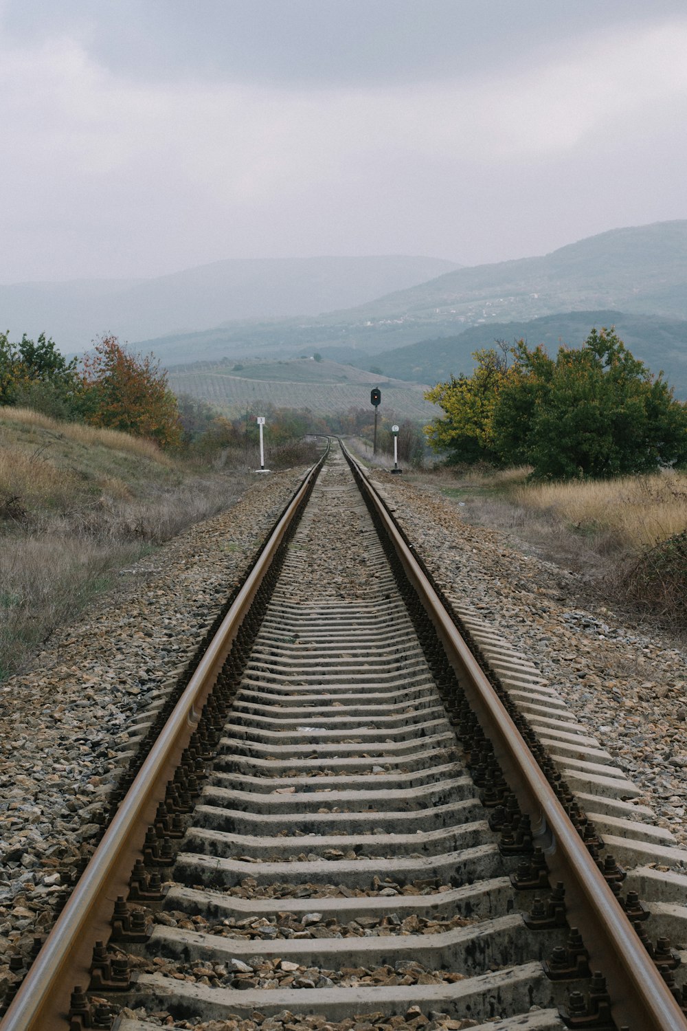 train rail near green grass field during daytime