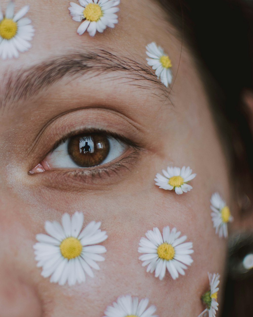 person with yellow and white flower on eyes