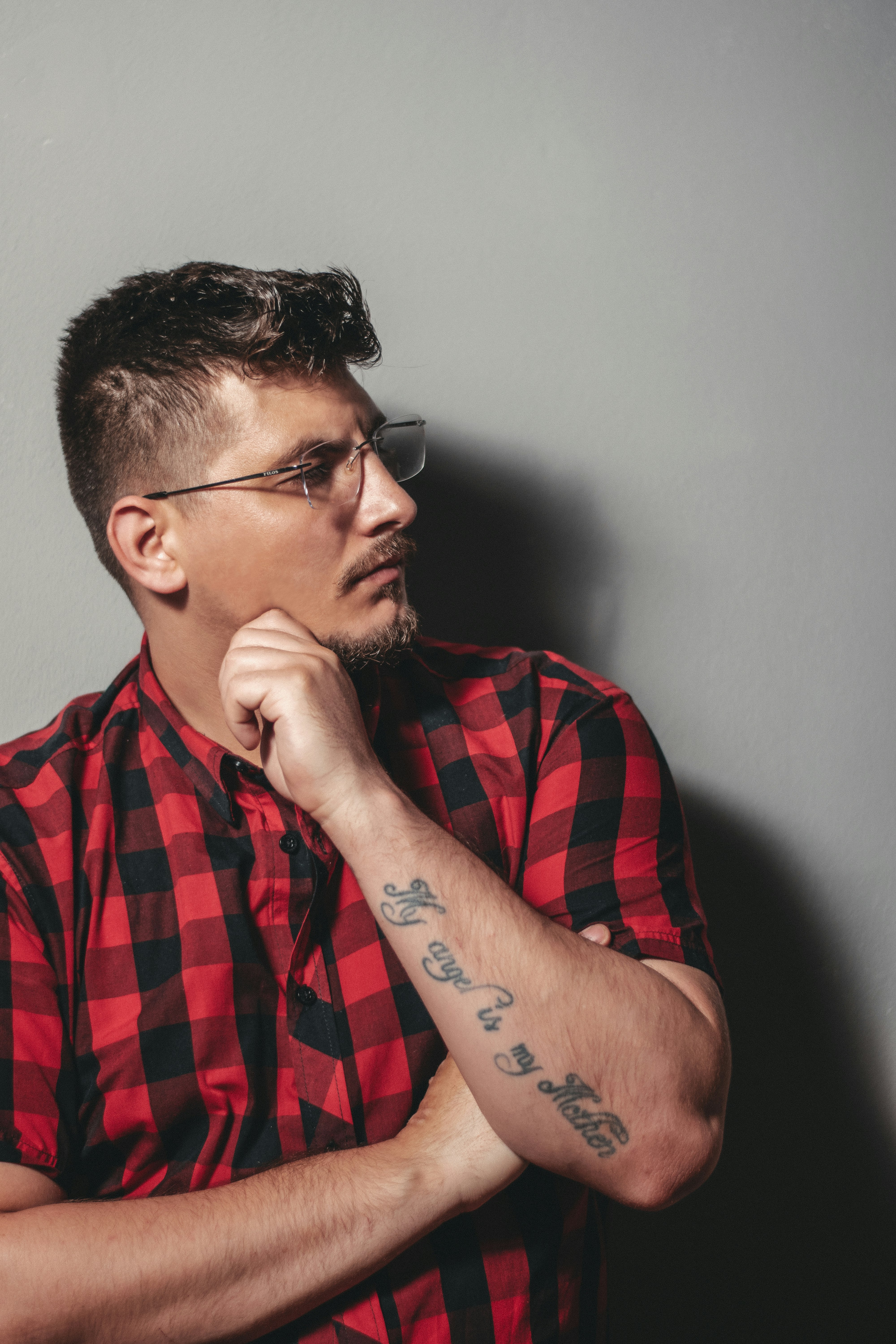 man in red and black plaid button up shirt wearing black framed eyeglasses