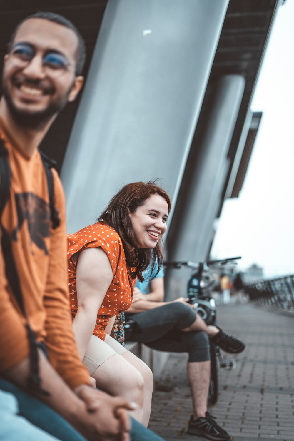 woman in orange blazer sitting on bench