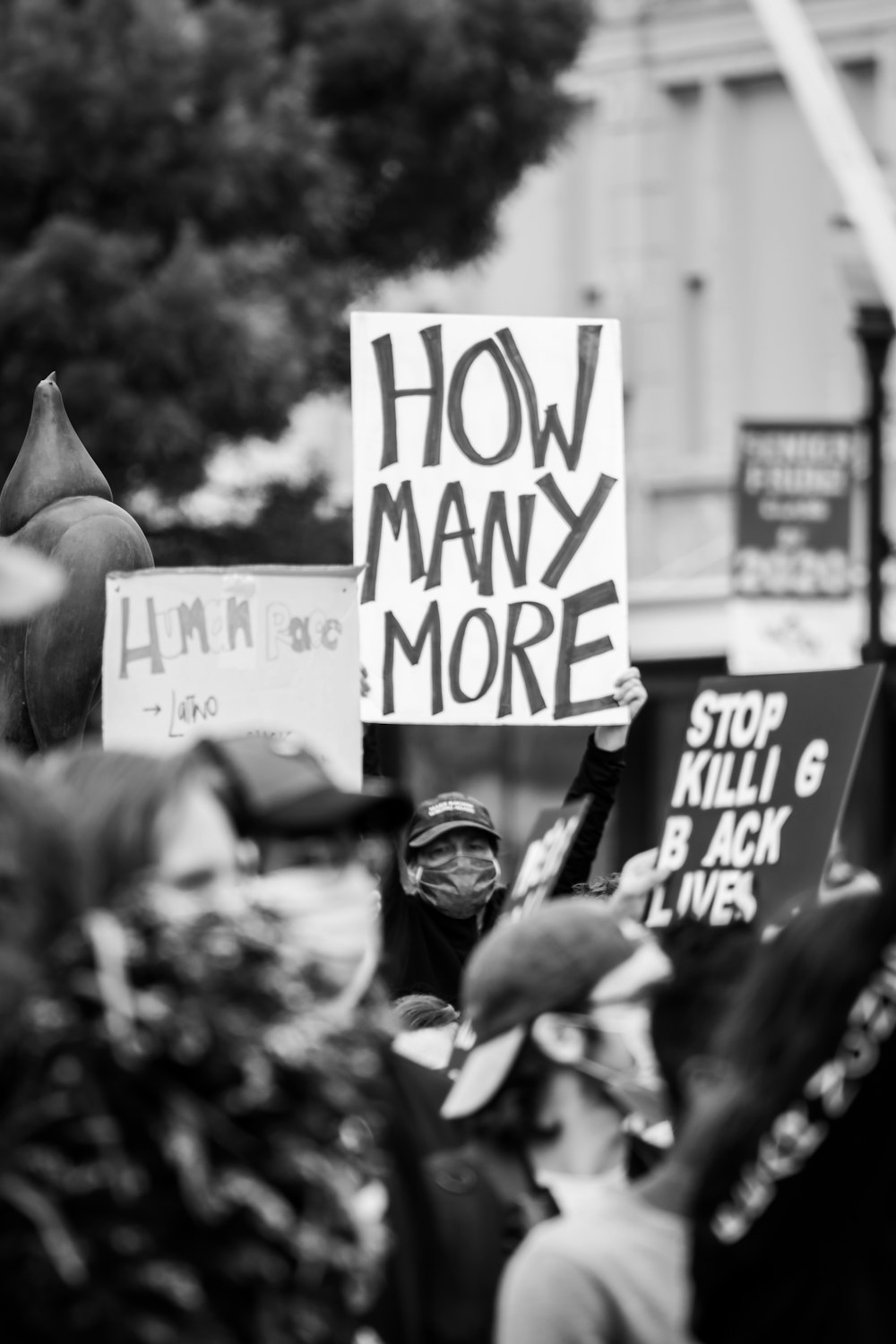 grayscale photo of people holding a signage