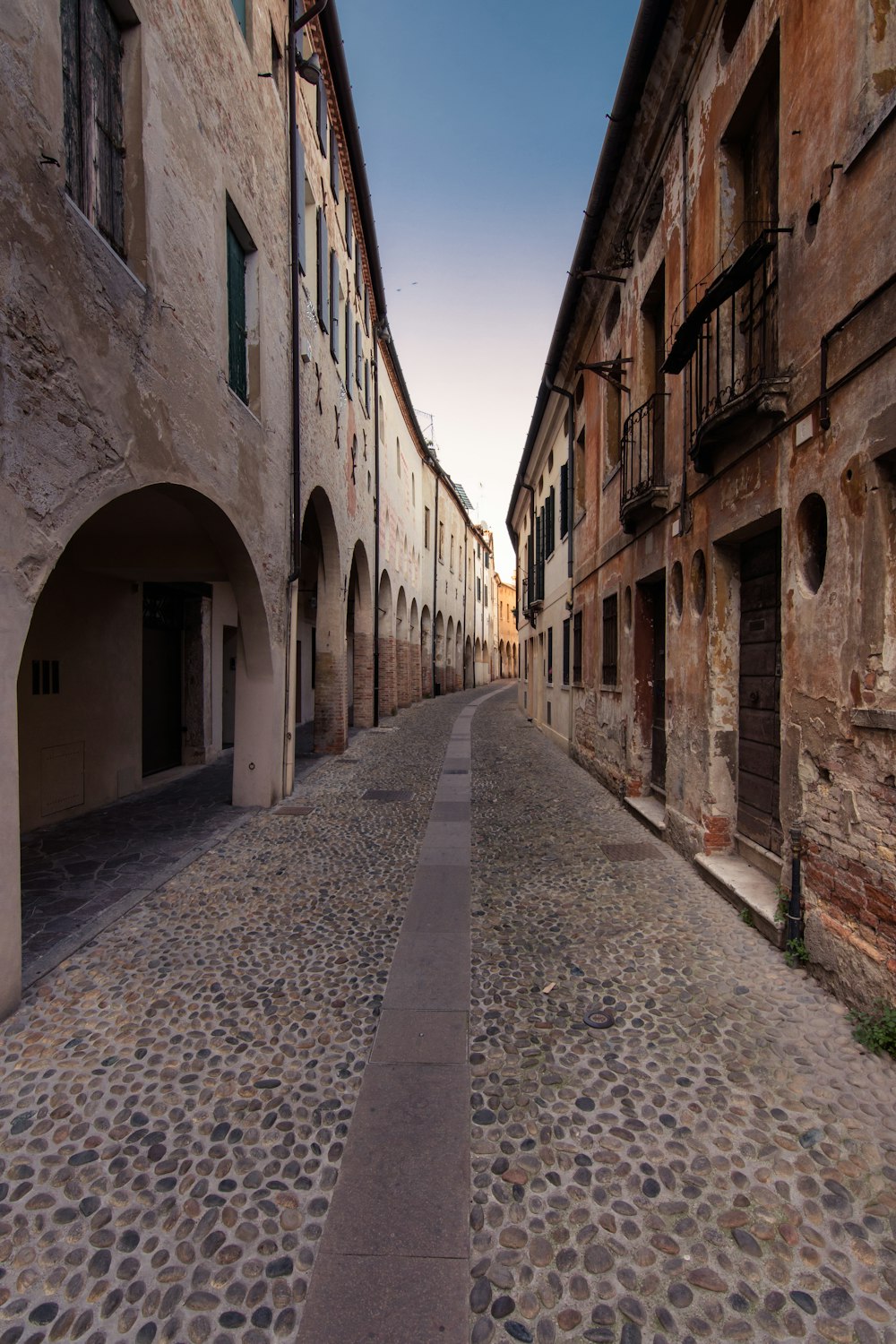 empty street in between of concrete buildings during daytime