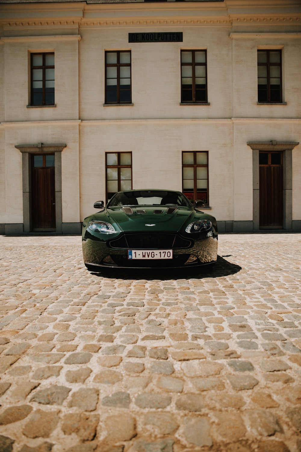 black porsche 911 parked in front of brown building