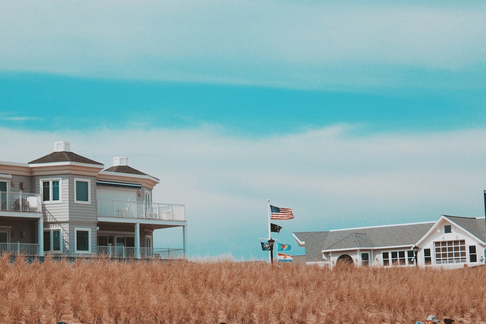 white and gray house on brown grass field under blue sky during daytime