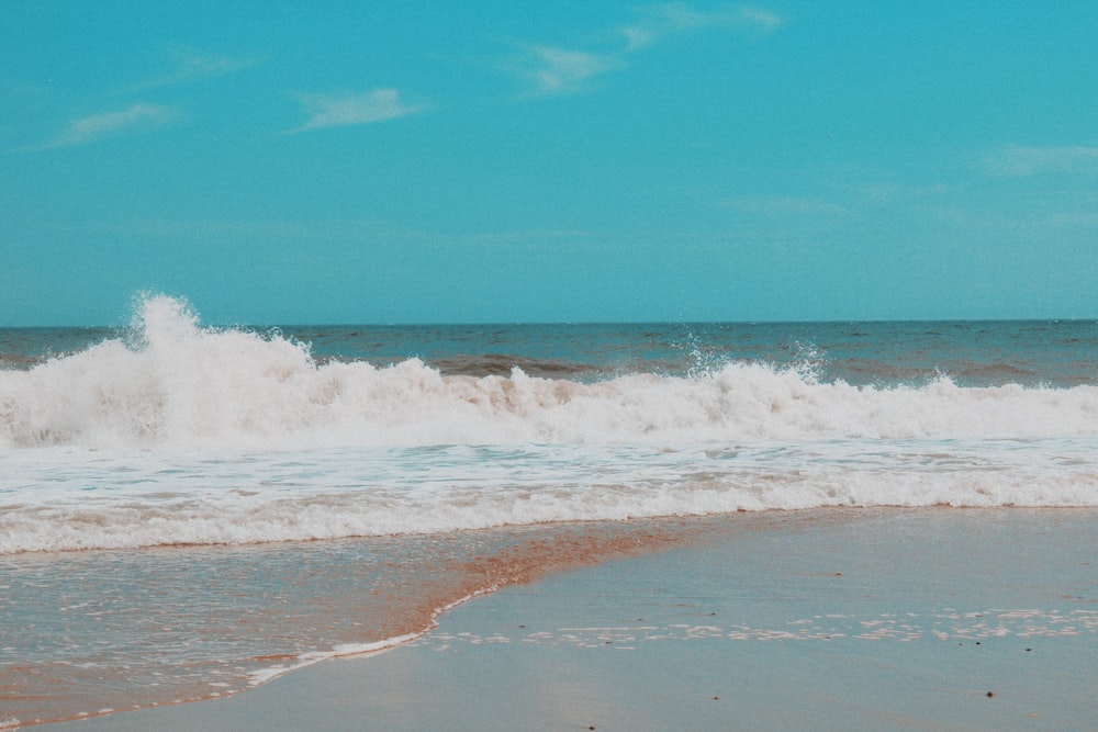 ocean waves crashing on shore during daytime