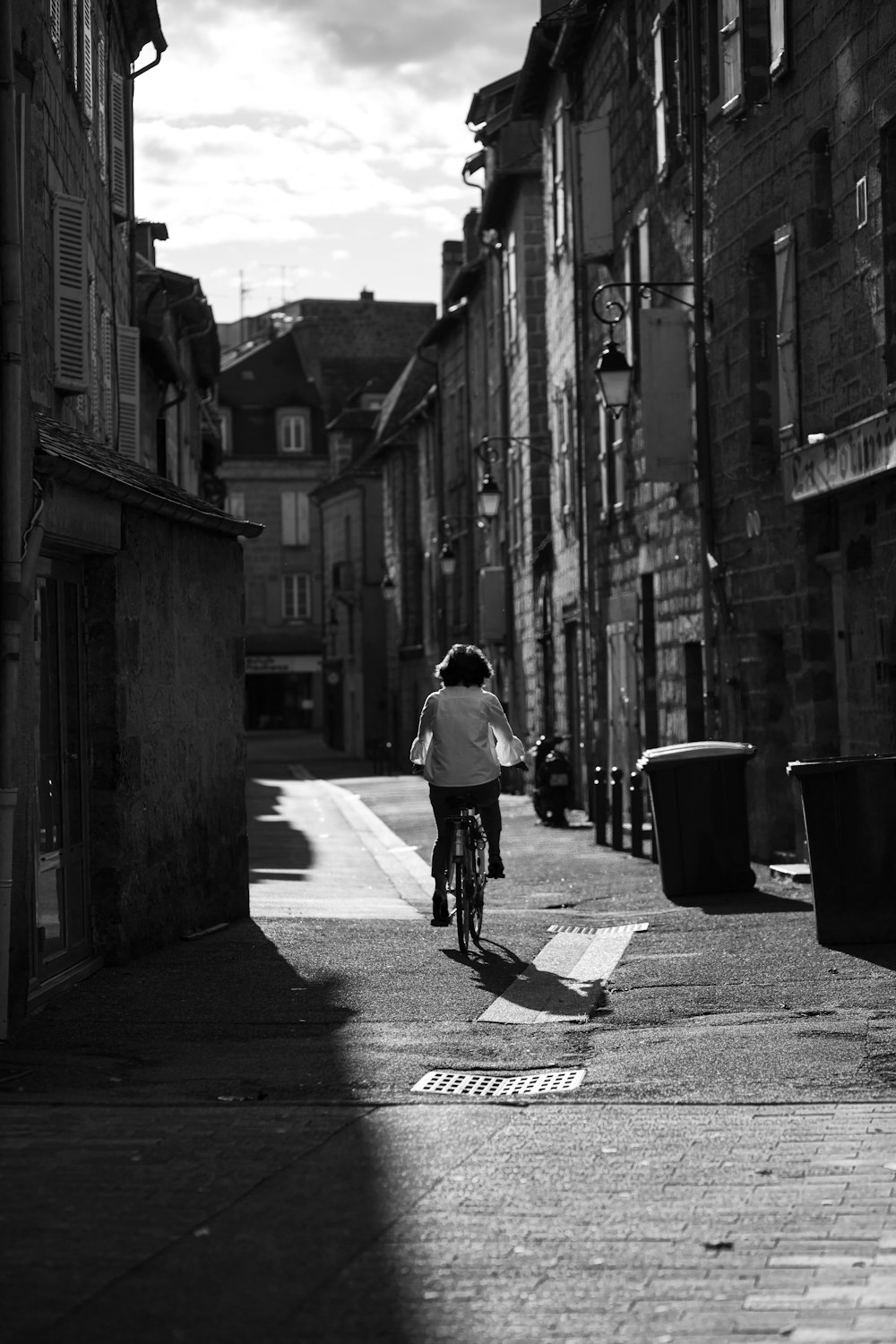 Mann im weißen Hemd fährt Fahrrad auf der Straße in Graustufenfotografie