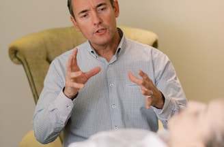 man in blue dress shirt sitting on yellow chair