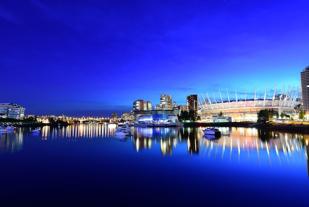 body of water near city buildings during night time