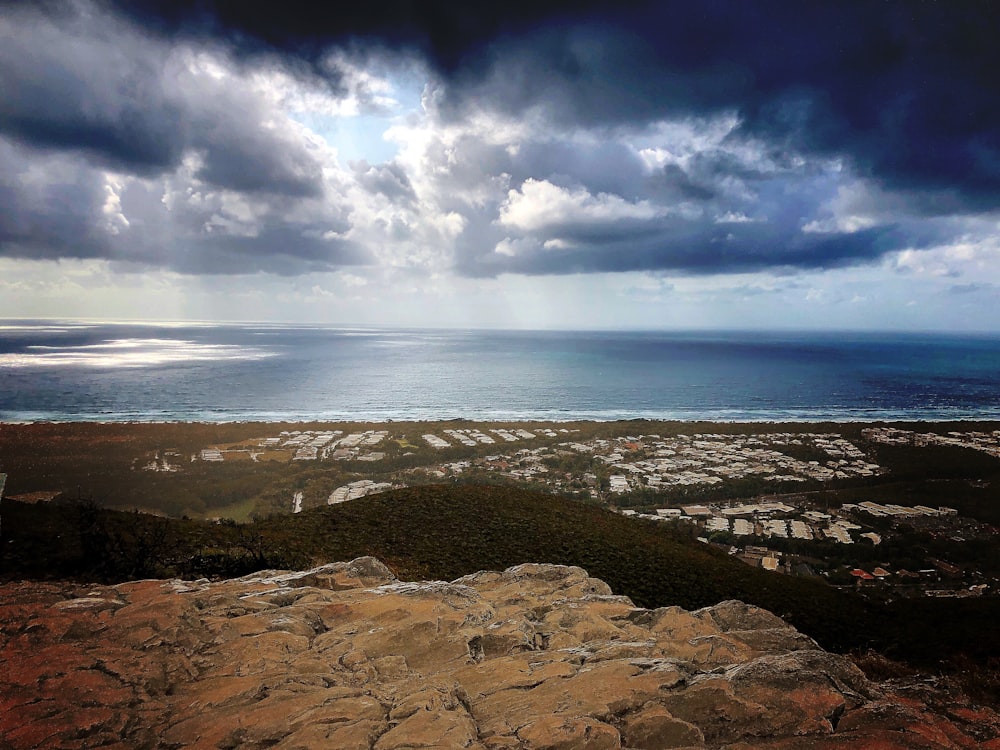 brown rocky shore under blue sky and white clouds during daytime