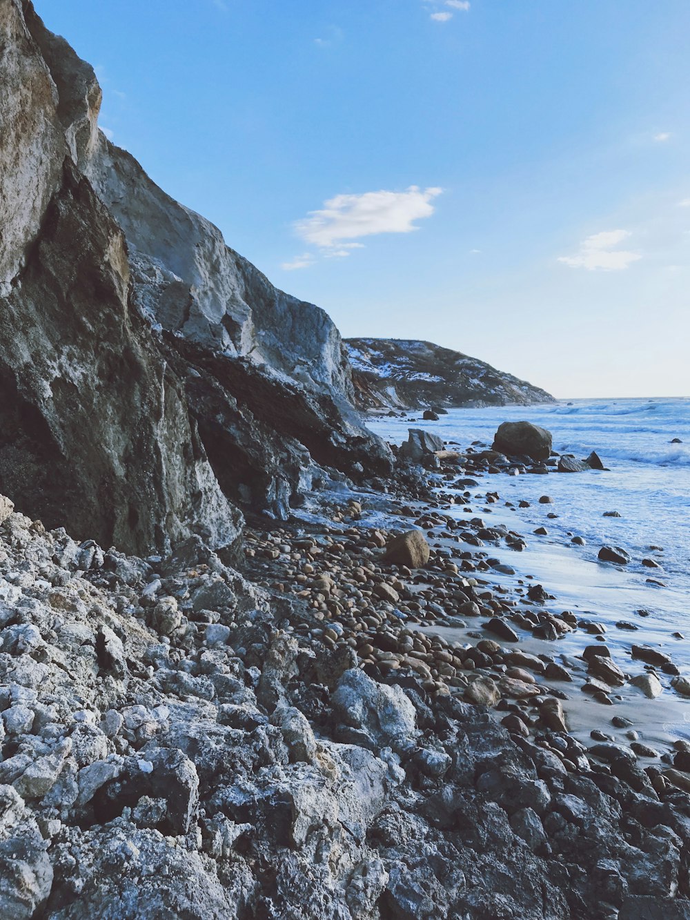 rocky shore with rocks under blue sky during daytime